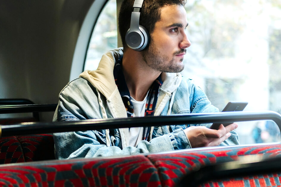 Persona con auriculares y teléfono inteligente en autobús